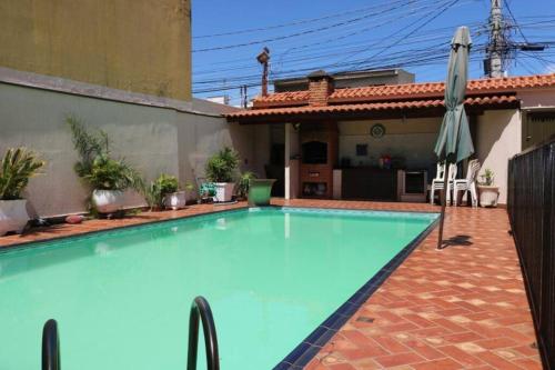 a large swimming pool in the backyard of a house at Lindo Sobrado Bandeirantes 4 quartos in Ribeirão Preto