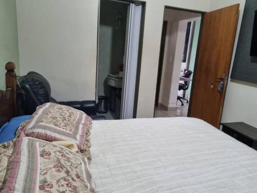 a bedroom with a bed with a blanket on it at Lindo Sobrado Bandeirantes 4 quartos in Ribeirão Preto