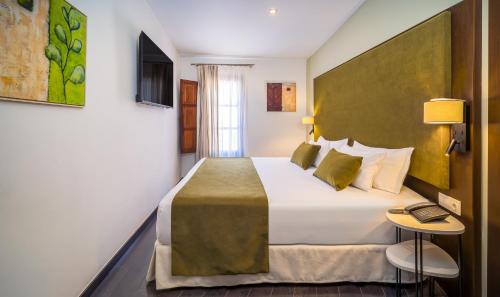 a hotel room with a large bed and a window at Occidental Pueblo Acantilado in El Campello