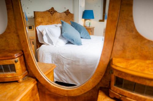 a bedroom with a bed in a large mirror at 1448 Antica Dimora Al Merlo Bianco in Cividale del Friuli