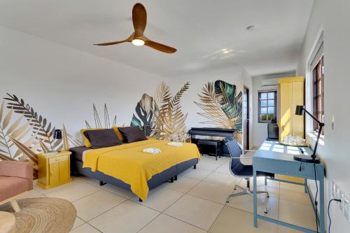 a bedroom with a bed and a desk and a piano at Boutique Hotel Wanapa - Adult Friendly - 14 years and older in Kralendijk