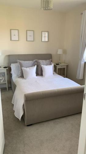 1 dormitorio con 1 cama grande con sábanas y almohadas blancas en 3 bedroom detached house, en Cononbridge