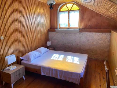a small bedroom with a bed and a window at Detached stone house with access to a large garden near beach in Kemer