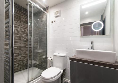 La salle de bains est pourvue de toilettes, d'un lavabo et d'une douche. dans l'établissement Derby Osmaston 1 Bedroom Apartment w/Free Parking, à Derby