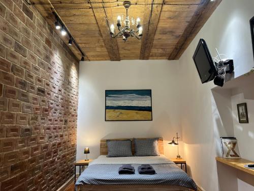 um quarto com uma cama e uma parede de tijolos em Loft-style apt on Virmenska str em Lviv