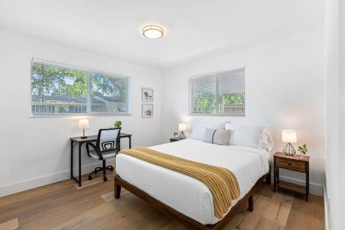 a bedroom with a bed and a desk and two windows at The Perfect Escape @Lake Ridge in Fort Lauderdale