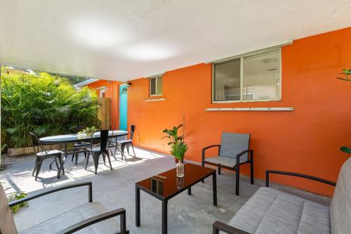 a patio with a table and chairs and an orange wall at The Perfect Escape @Lake Ridge in Fort Lauderdale