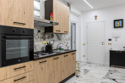 a kitchen with wooden cabinets and a stove top oven at Maison 31 -Luxury Apartments in Santa Marinella