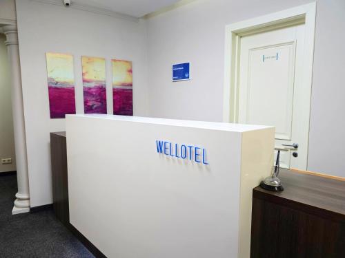 a white exhibit in a room with paintings on the wall at Wellotel Chornomorsk in Chornomorsk
