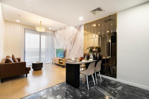 a dining room and living room with a table and chairs at LUMIÈRE RESIDENT LUXURY SUITE in Ho Chi Minh City