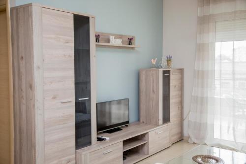 un gran centro de entretenimiento de madera con TV de pantalla plana en Apartment near the circuit of Serres and centre!!! en Serres