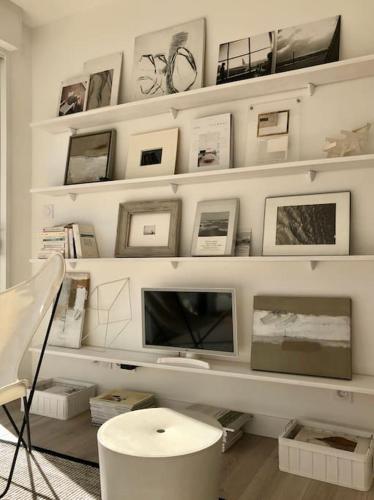 - un salon avec des étagères blanches et une chaise blanche dans l'établissement Appartement Ty Noe - Concarneau, à Concarneau