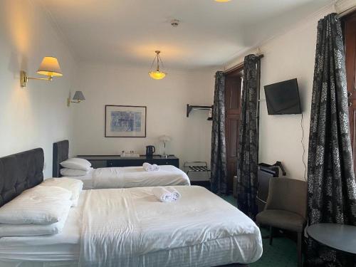 a hotel room with two beds and a couch at Argyll Arms Hotel in Campbeltown