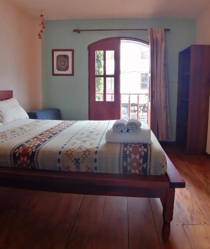 a bedroom with a bed with two towels on it at Hotel Doña Esther in Otavalo
