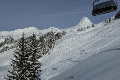 a snow covered mountain with a ski lift at Alpine Lifestyle Berghotel Madlener in Damuls