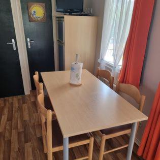 een tafel met stoelen en een fles erop bij Mobile Home cosy 4/6 pers in Hyères