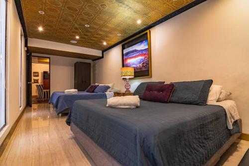 1 dormitorio con 2 camas y TV en la pared en 3BR, 5Stars, Casa,WiFi,Bar,CamasKING, Bogota, en Bogotá