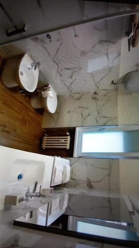 bagno con lavandino e parete in marmo di ALBEA a Roma