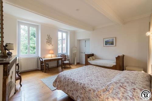 um quarto com uma cama, uma secretária e uma cadeira em L'Arénoulat em Aspet