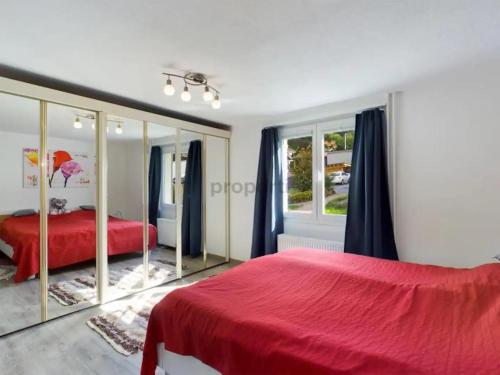 1 dormitorio con cama roja y espejo en Feriendomizil im Naturparadies en Luchsingen