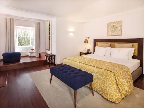 a bedroom with a large bed and a blue chair at Casa Senhoras Rainhas - Óbidos - by Unlock Hotels in Óbidos