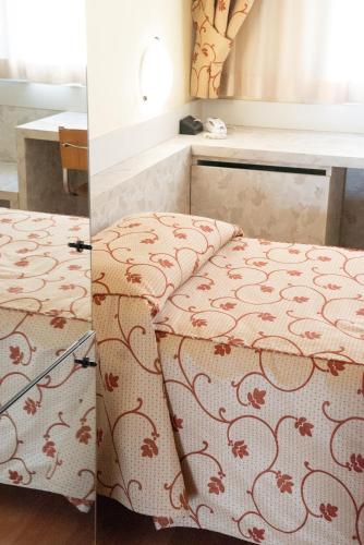 a bedroom with a bed with a patterned blanket at Melas Hotel in Merate