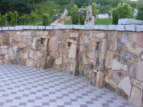 a stone retaining wall with a checkered floor at Tenuta Su Vrau in Posada