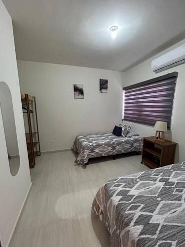 a bedroom with two beds and a window at Casa vacacional Mar&Paz in La Paz