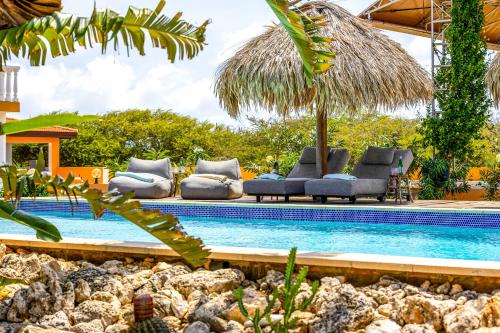 a pool with chaise lounge chairs and a resort at Boutique Hotel Wanapa in Kralendijk