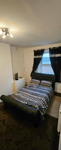 a bedroom with a large bed with a window at The Luxe - Entire House in Huddersfield
