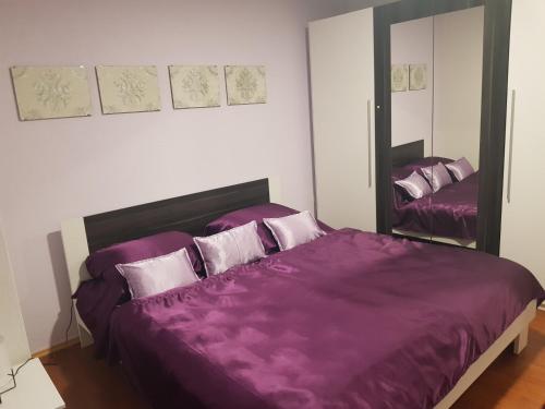 a bedroom with a purple bed and a mirror at Apartment Ivan in Posušje