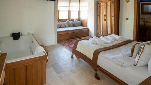 a bedroom with two beds and a tub and a sink at Aura Village Alaçatı in Alacati