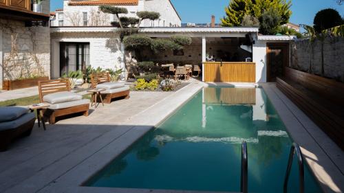 a swimming pool in a backyard with a house at Aura Village Alaçatı in Alacati