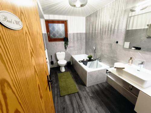a bathroom with a tub and a toilet and a sink at Bergfreude Chalet in Braunlage