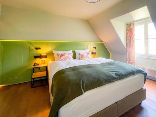 Schlafzimmer mit einem großen Bett mit einem grünen Kopfteil in der Unterkunft Boutique Hotel Orangerie in Düsseldorf