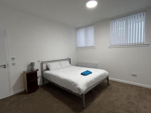 a white bedroom with a bed and two windows at 3 Bed House Buckie Contractors Business Travellers in Buckie