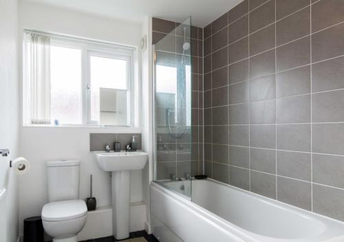 a bathroom with a tub and a toilet and a sink at Levon House 2 Bed Apt with Netflix & Parking in Coventry in Longford