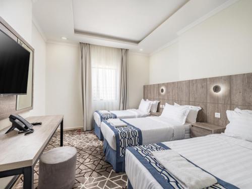 a hotel room with two beds and a television at Alayam Elite Hotel in Makkah