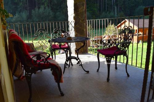 un patio con sillas, una mesa y una mesa con sillas en Casa George, en Răchiţele