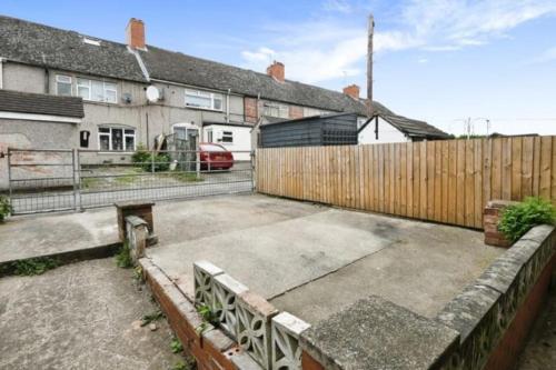 a parking lot in front of a house with a fence at Spacious and homely House in Nottingham