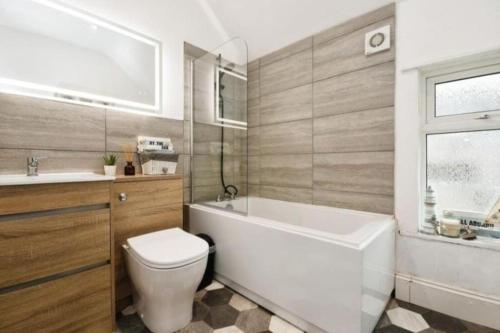 e bagno con vasca, servizi igienici e lavandino. di Spacious and homely House a Nottingham