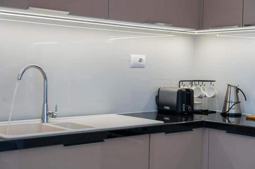 Beachfront Apartments- Horizon Residence في سارنده: طاولة مطبخ مع حوض وميكروويف