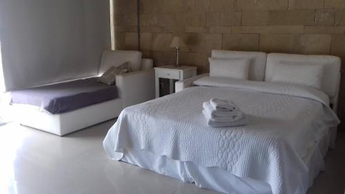 a white bedroom with a white bed and a chair at Linda Bay Spa de Mar in Mar de las Pampas