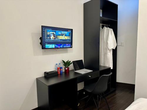 een kamer met een bureau, een laptop en een televisie bij Victoria Hotel in Ho Chi Minh-stad