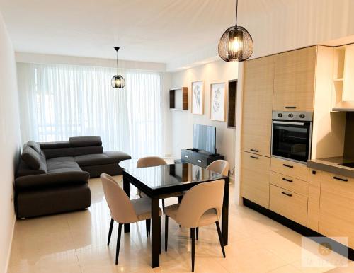 a kitchen and living room with a table and chairs at Ta' Tereża Seafront Apartments in St. Julianʼs