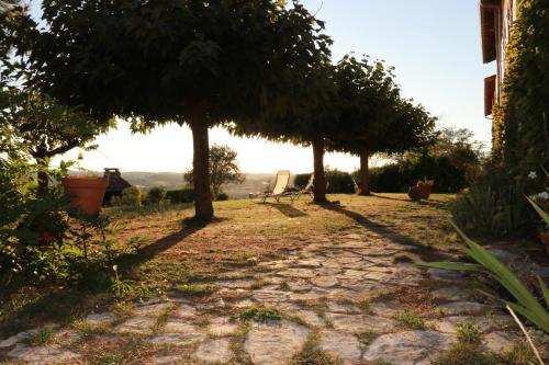 a path with trees and a bench in a yard at Ma Maison sur la Colline in Escosse