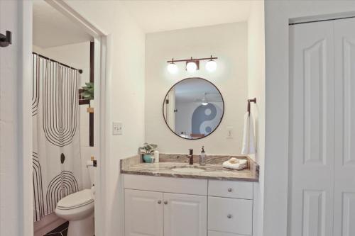 a white bathroom with a sink and a mirror at Ying Yang Suite King Bed Zen Condo in Gainesville