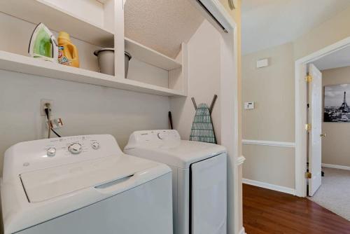 a laundry room with a white washer and dryer at Breeze on Inn- Mins to Ft Jackson in Columbia