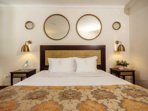 a bedroom with a large bed with two mirrors on the wall at Casa Senhoras Rainhas - Óbidos - by Unlock Hotels in Óbidos