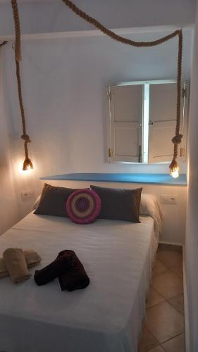 a bedroom with a large white bed with a mirror at La Casa del Callejón in Vejer de la Frontera
